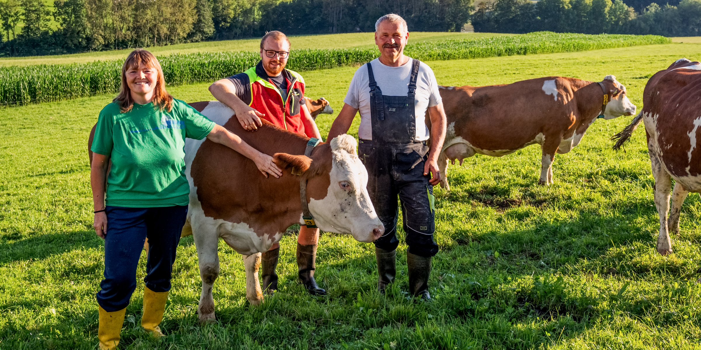 Familie Gruber steht beisammen um eine Kuh und streichelt diese.