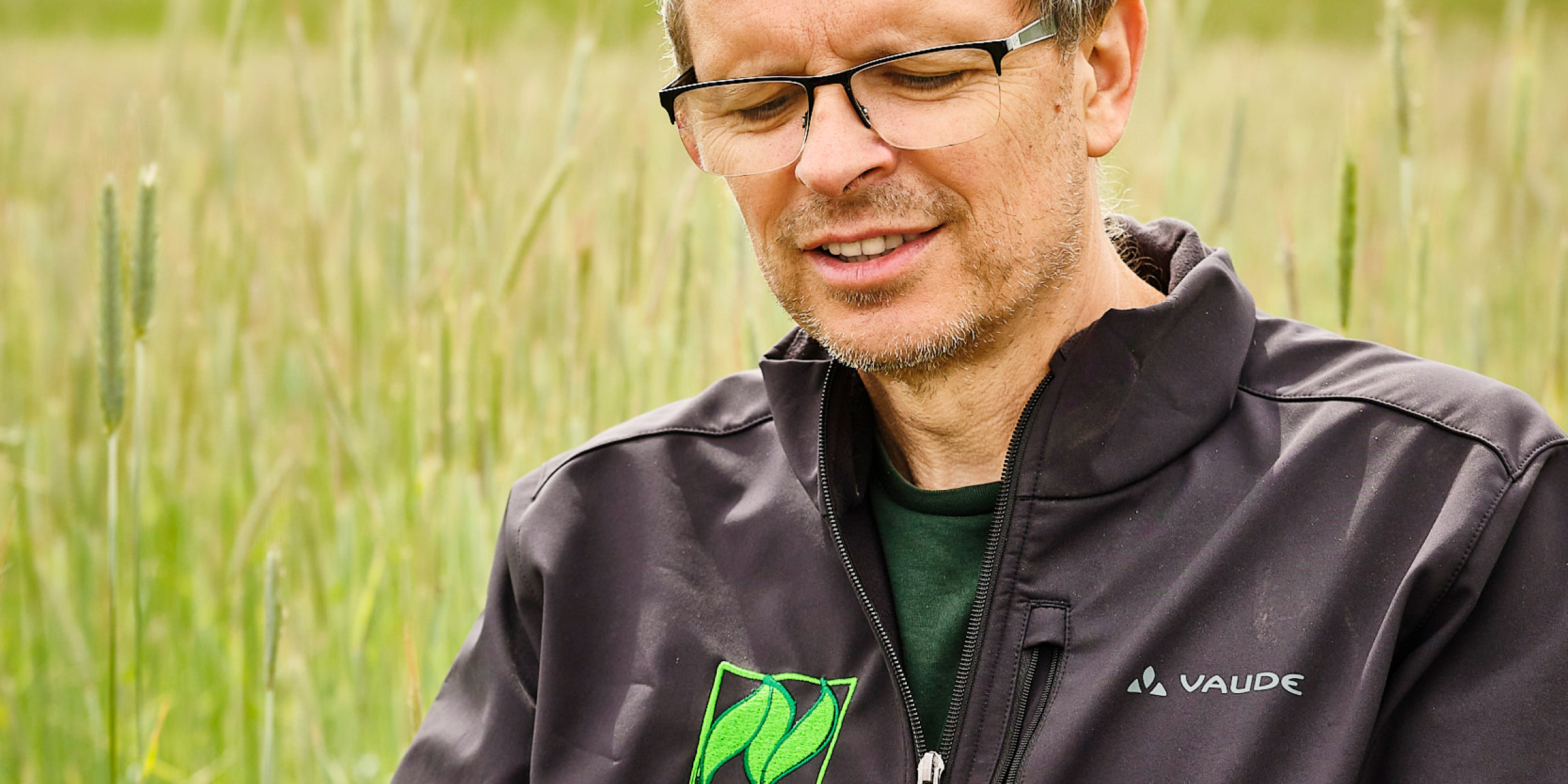 Georg Hau betrachtet eine Getreide-Ähre.