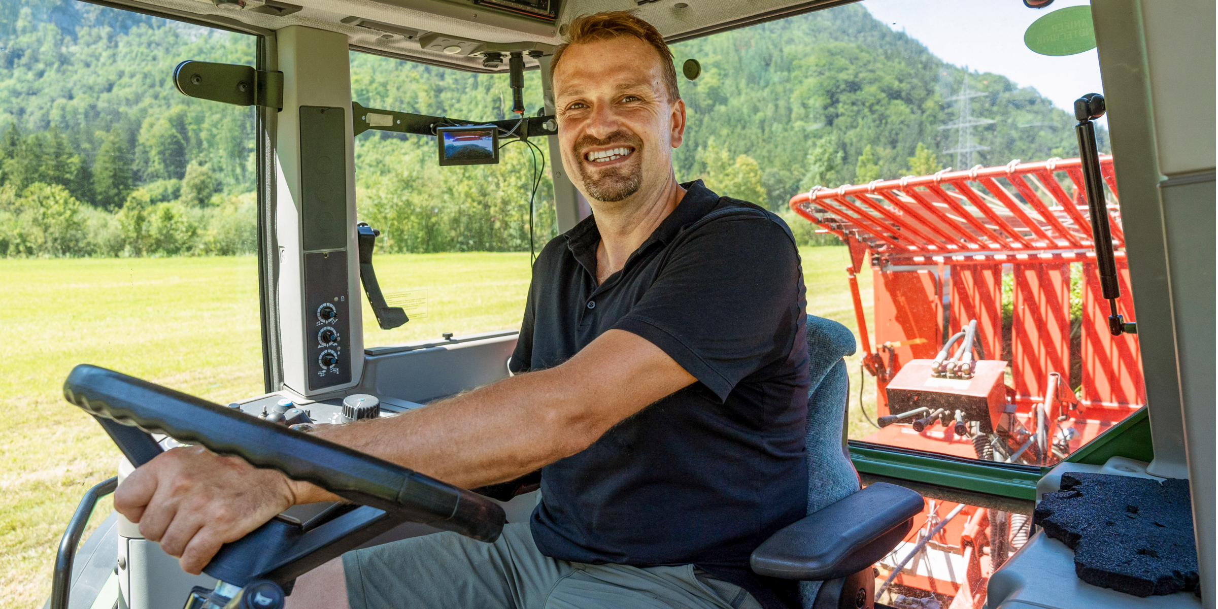Herr Kronreif im Führerhaus des Traktors.