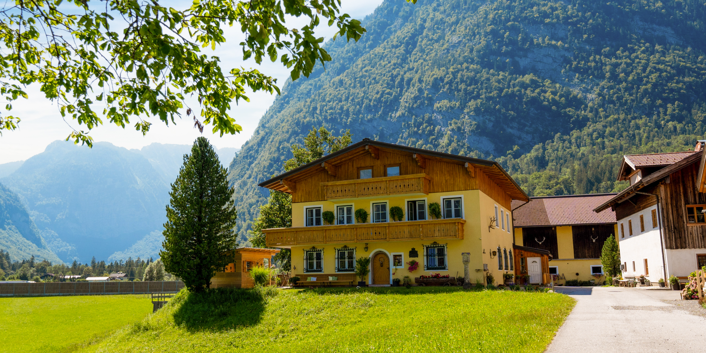 Prachtvolles Bauernhaus vor einer Bergkulisse.