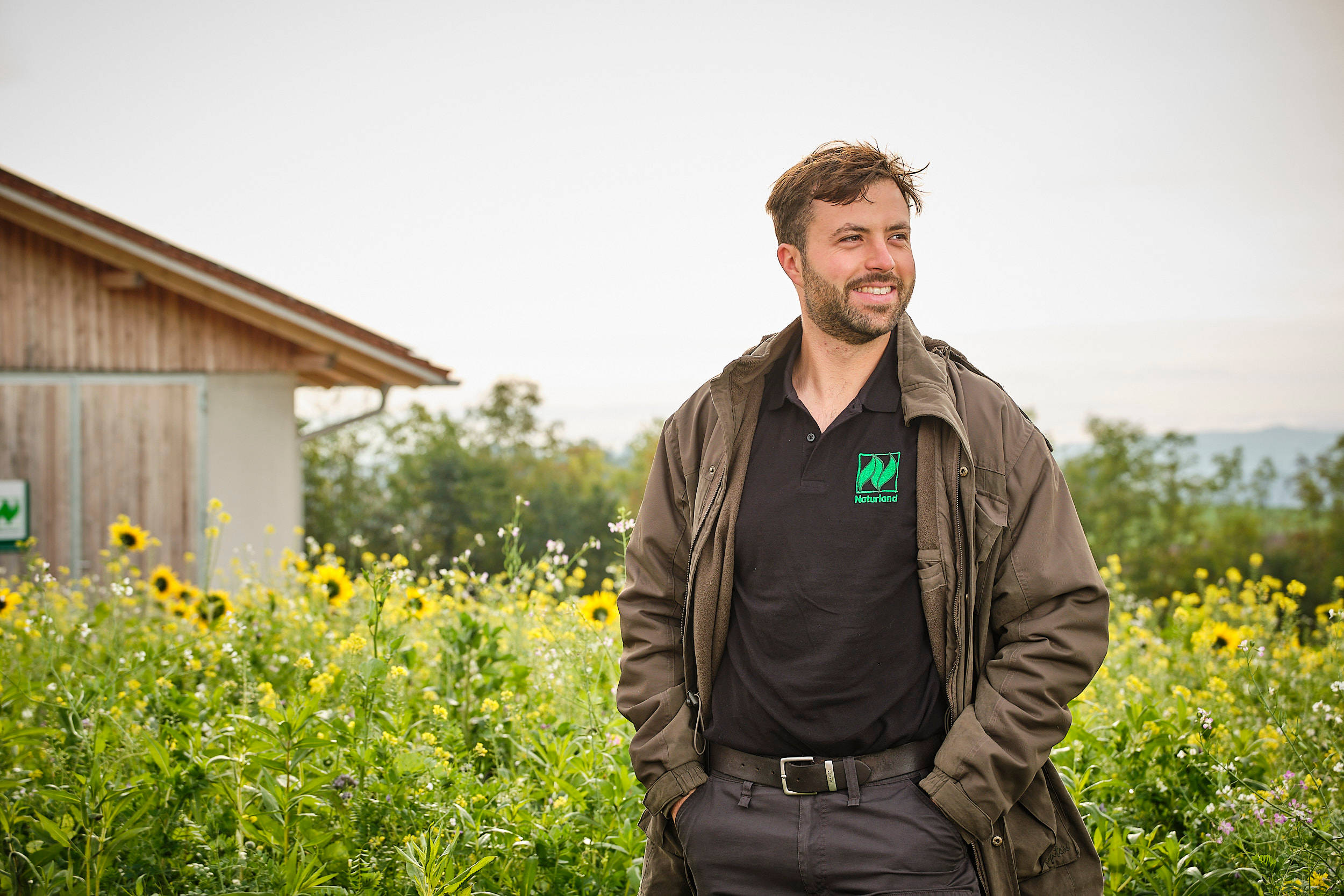 Naturland-Landwirt Stefan Meier steht vor einer blühenden Anbaufläche.