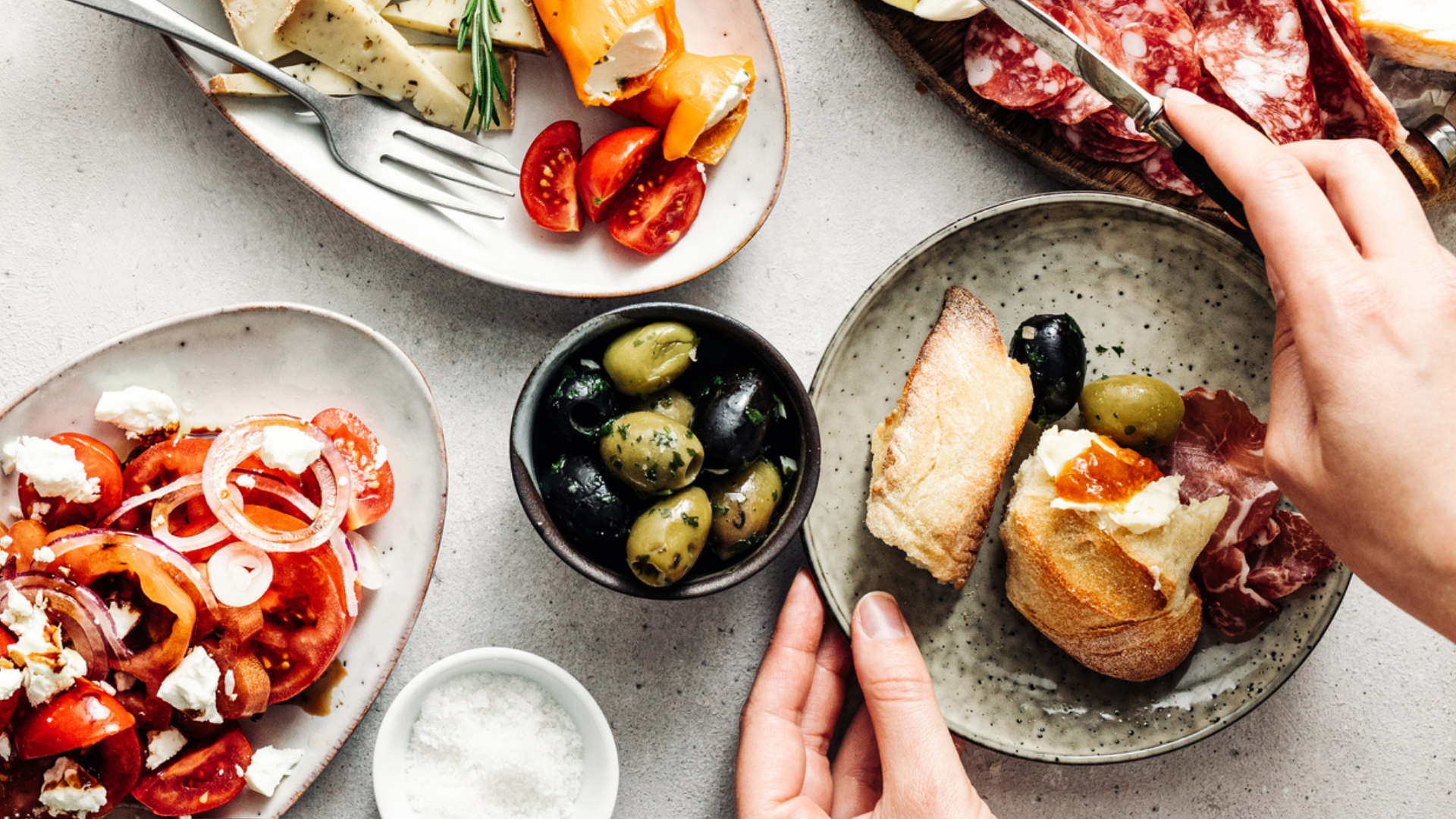 Antipasti-Auswahl mit Käse, Wurst, Oliven und Tomatensalat.