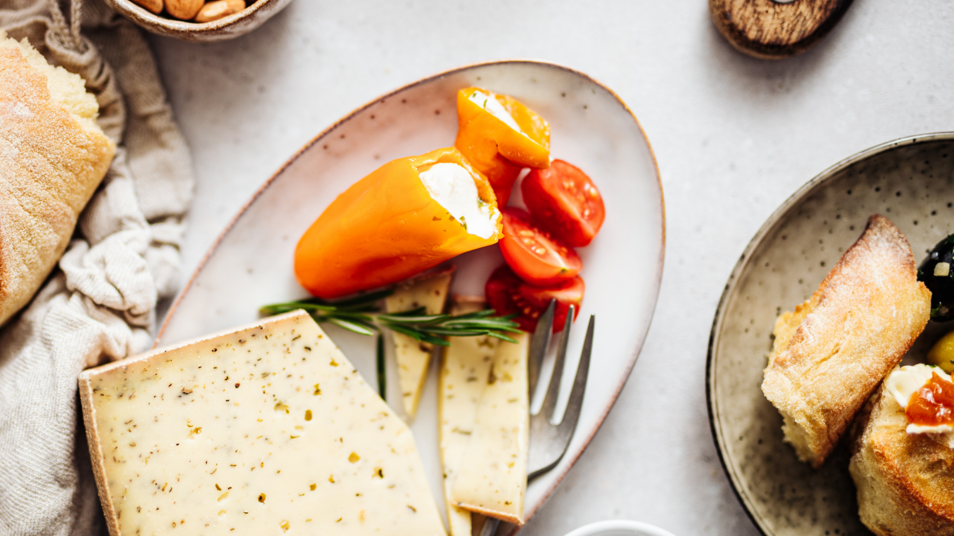 Antipasti-Platte mit Käse, Gemüse und Brot von oben.