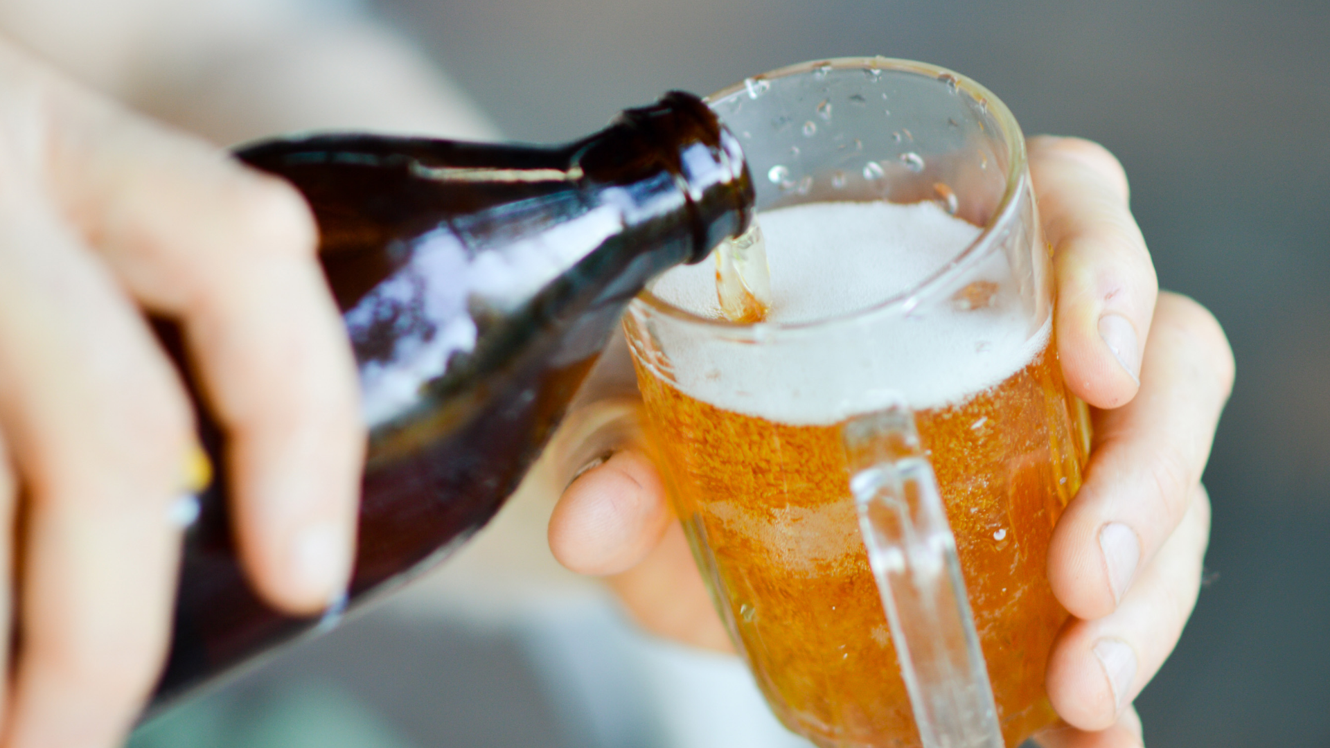 Bier wird in ein Glas mit Henkel gegossen.