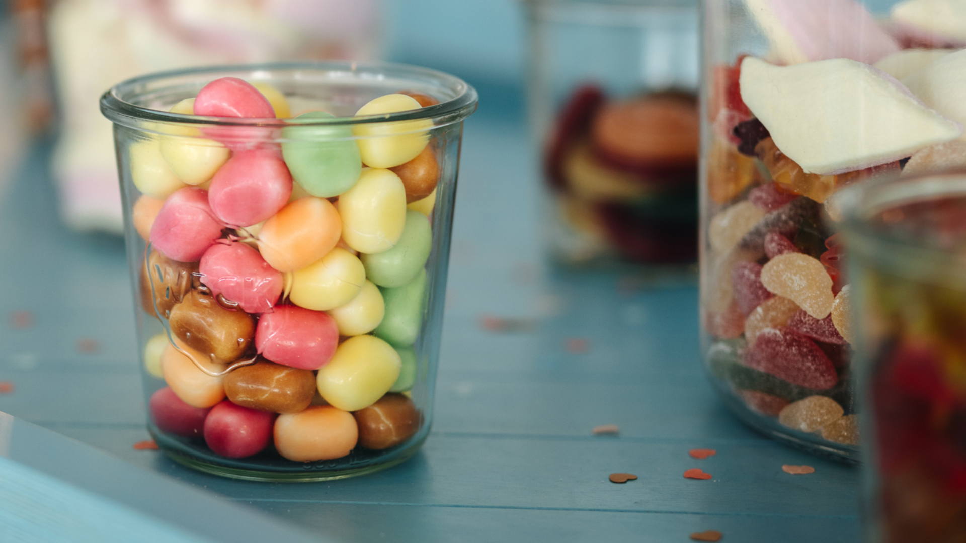 Gläser gefüllt mit bunten Süßigkeiten und Marshmallows.