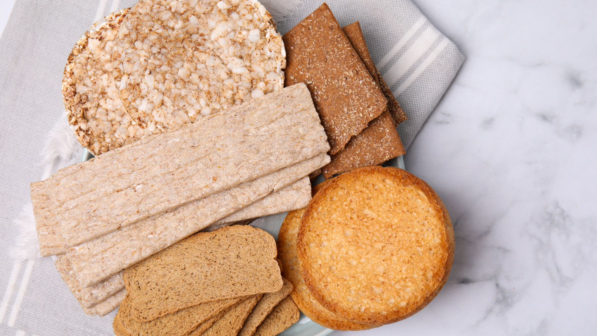 Knäckebrot, Zwieback und Reiswaffeln auf Marmor.