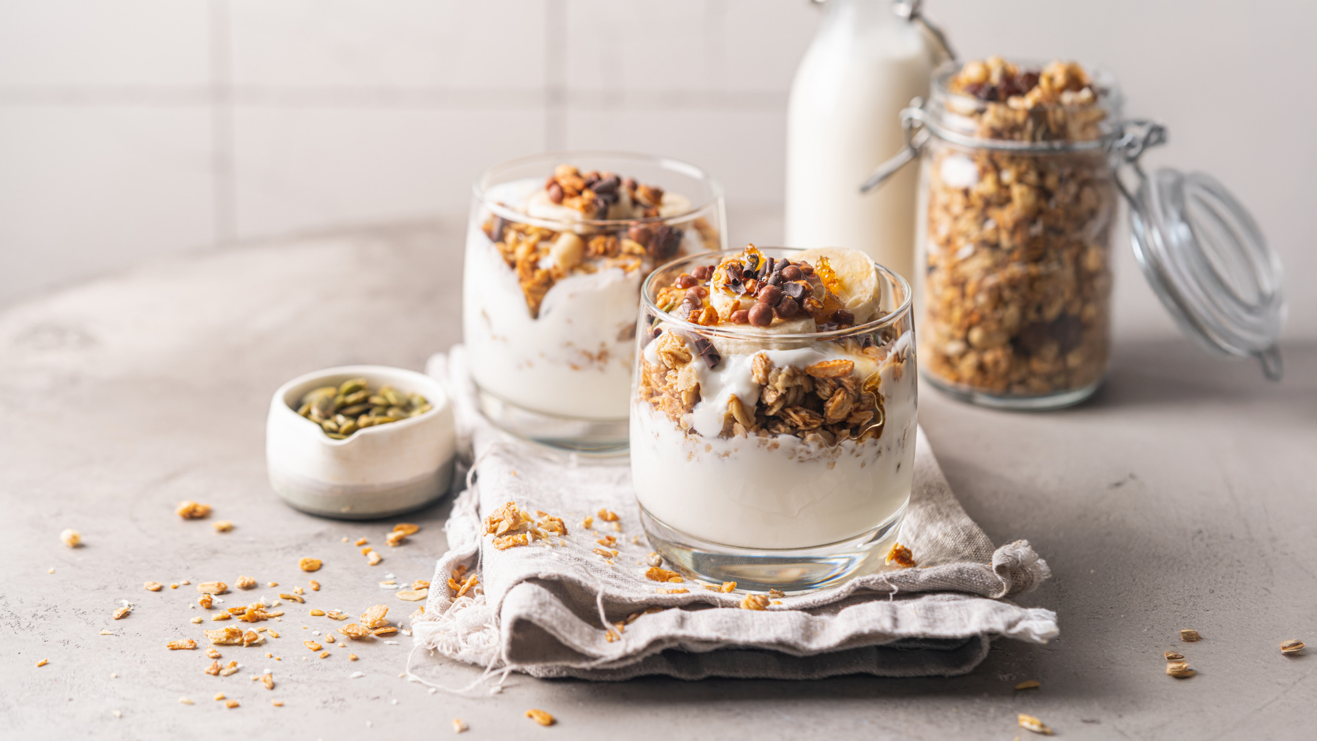 Joghurt mit Müsli, Banane, Nüssen und Kürbiskernen.
