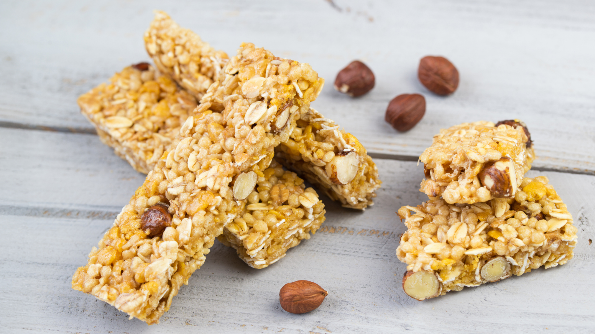 Müsliriegel mit Nüssen auf hellem Holztisch.