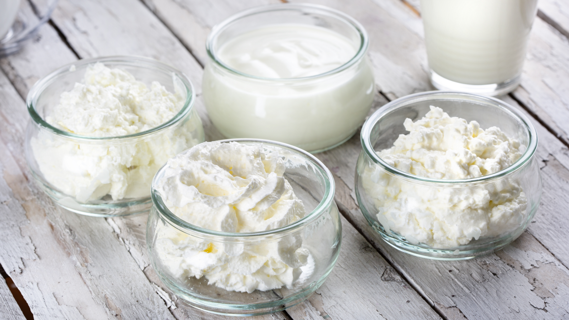 Sahne, Schmand, Quark und Milch in Gläsern.
