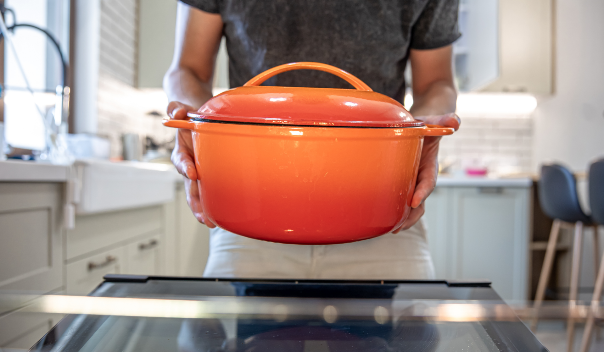 Eine Person hält einen großen Schmortopf.