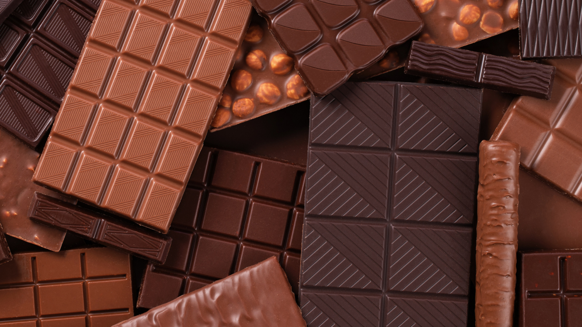 Verschiedene Schokoladensorten und -formen liegen dicht aneinander.