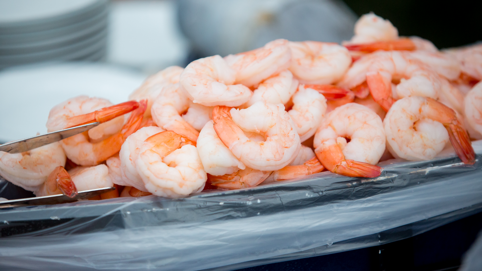 Gekochte Garnelen, aufgetürmt, mit Zange, Nahaufnahme.