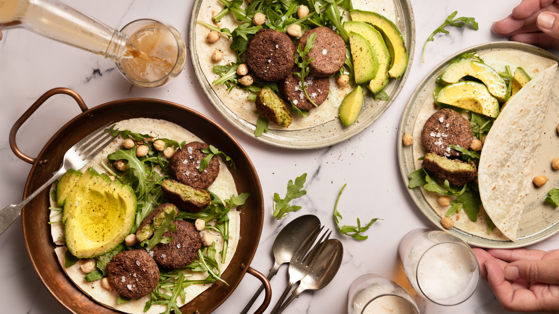 Gemüsebällchen-Wraps mit Avocado, Rucola und Kichererbsen.
