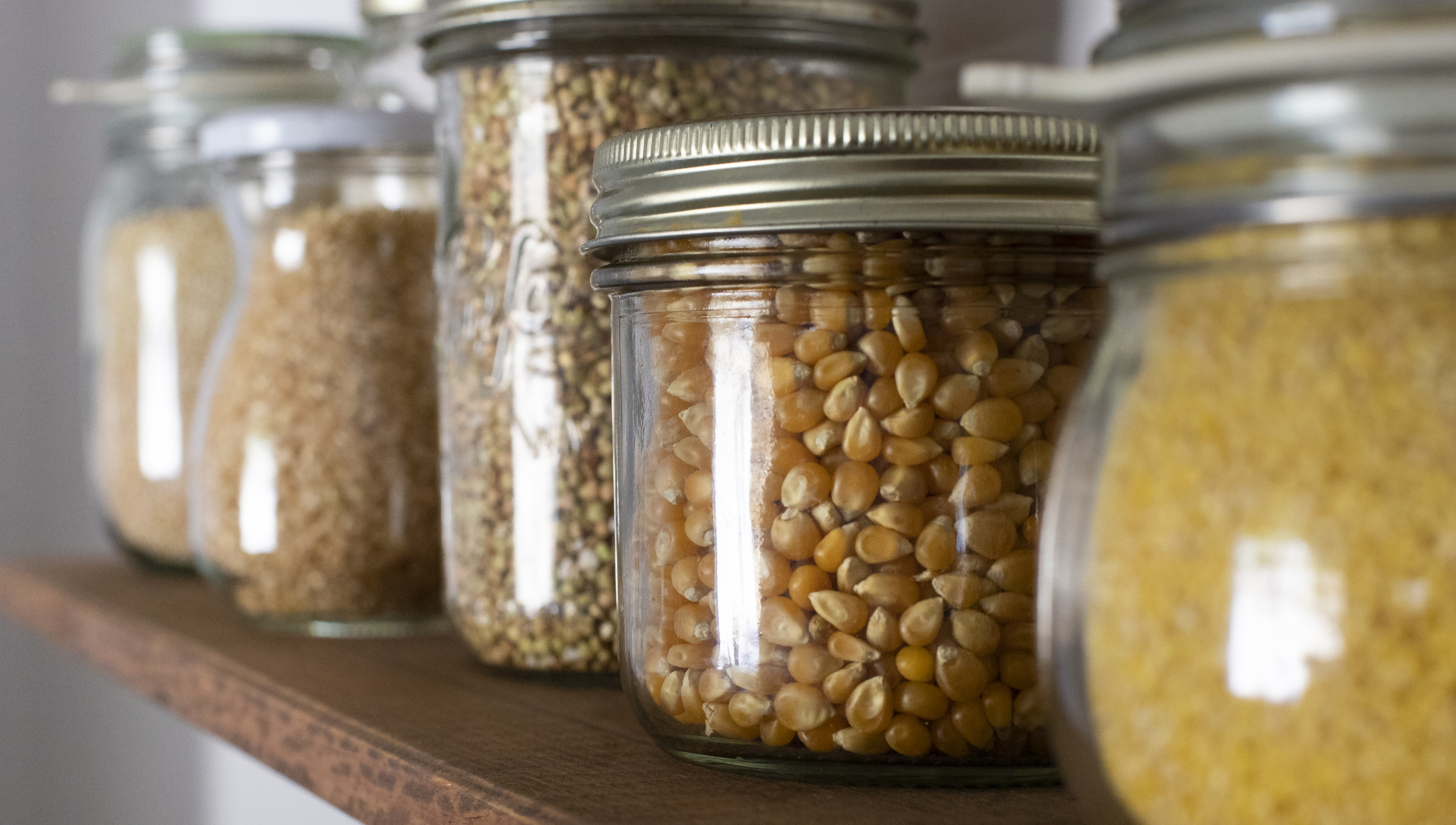 Ein Regalbrett mit trockenen Lebensmitteln in Gläser.