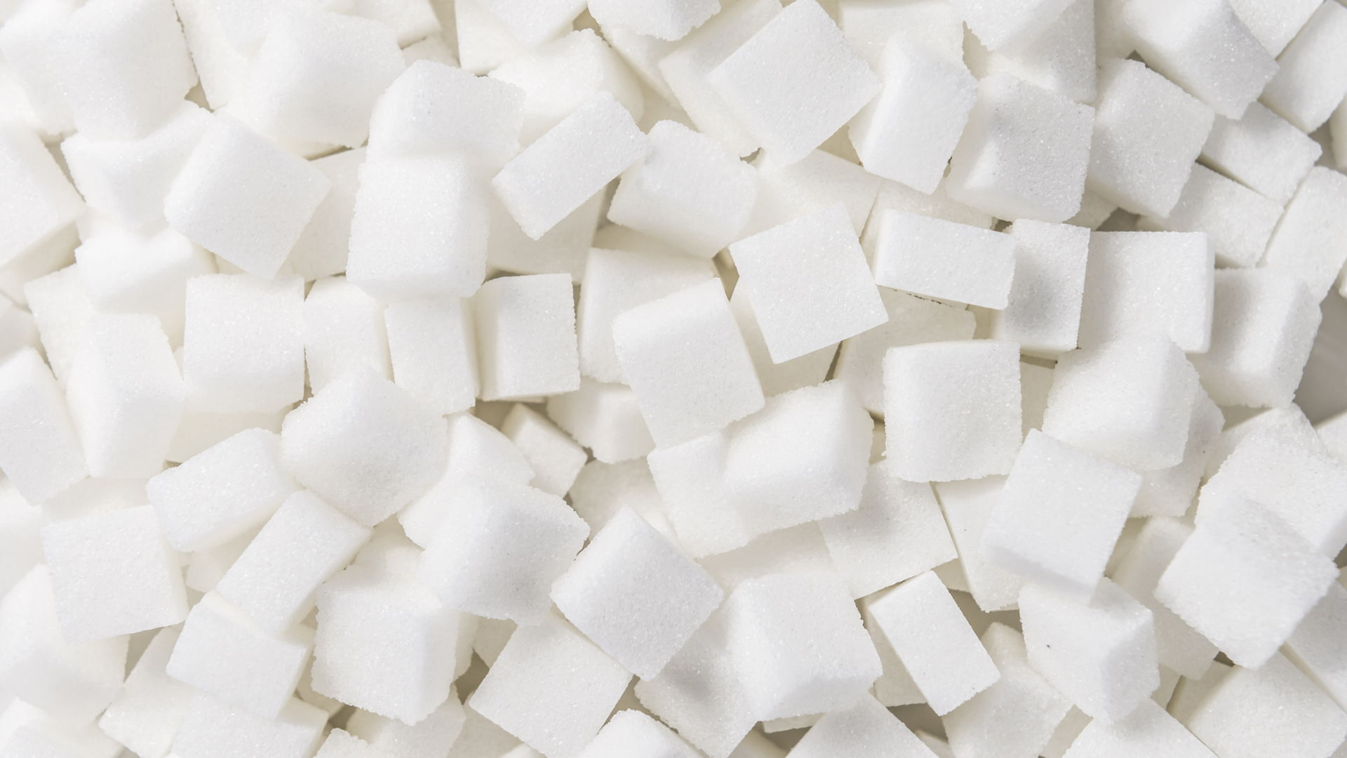 Nahaufnahme von weißen Zuckerwürfeln, unsortiert und dicht gepackt.