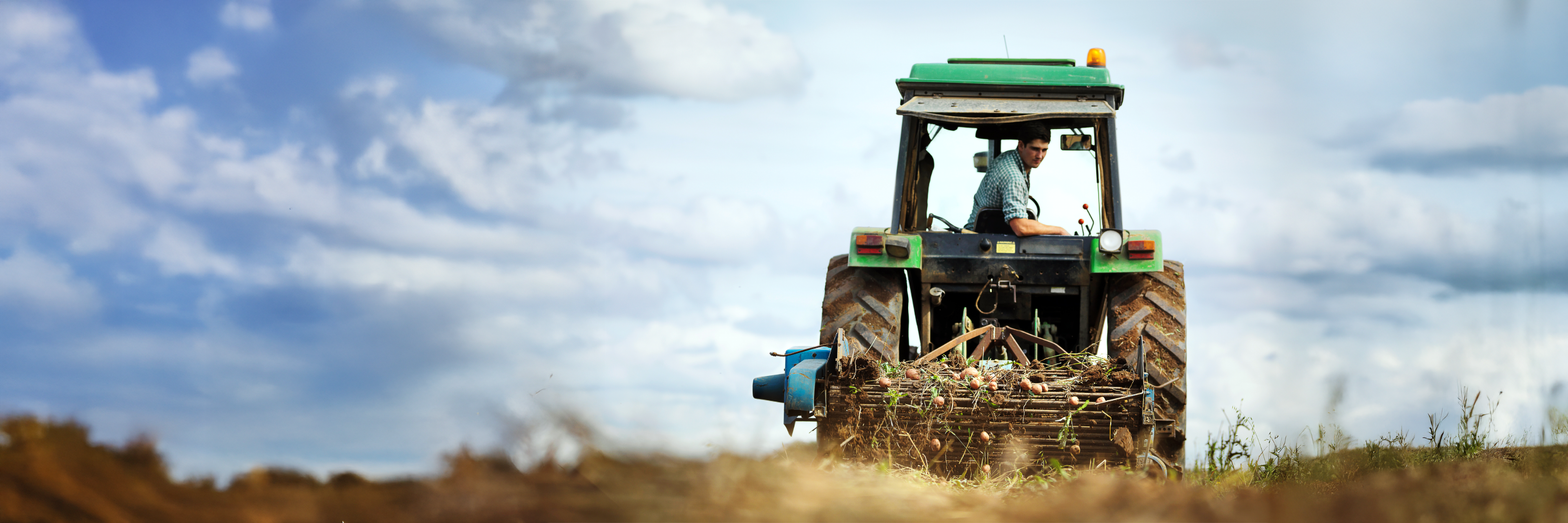 Ein Landwirt sitzt in seinem Tracktor und pflügt ein Feld um.