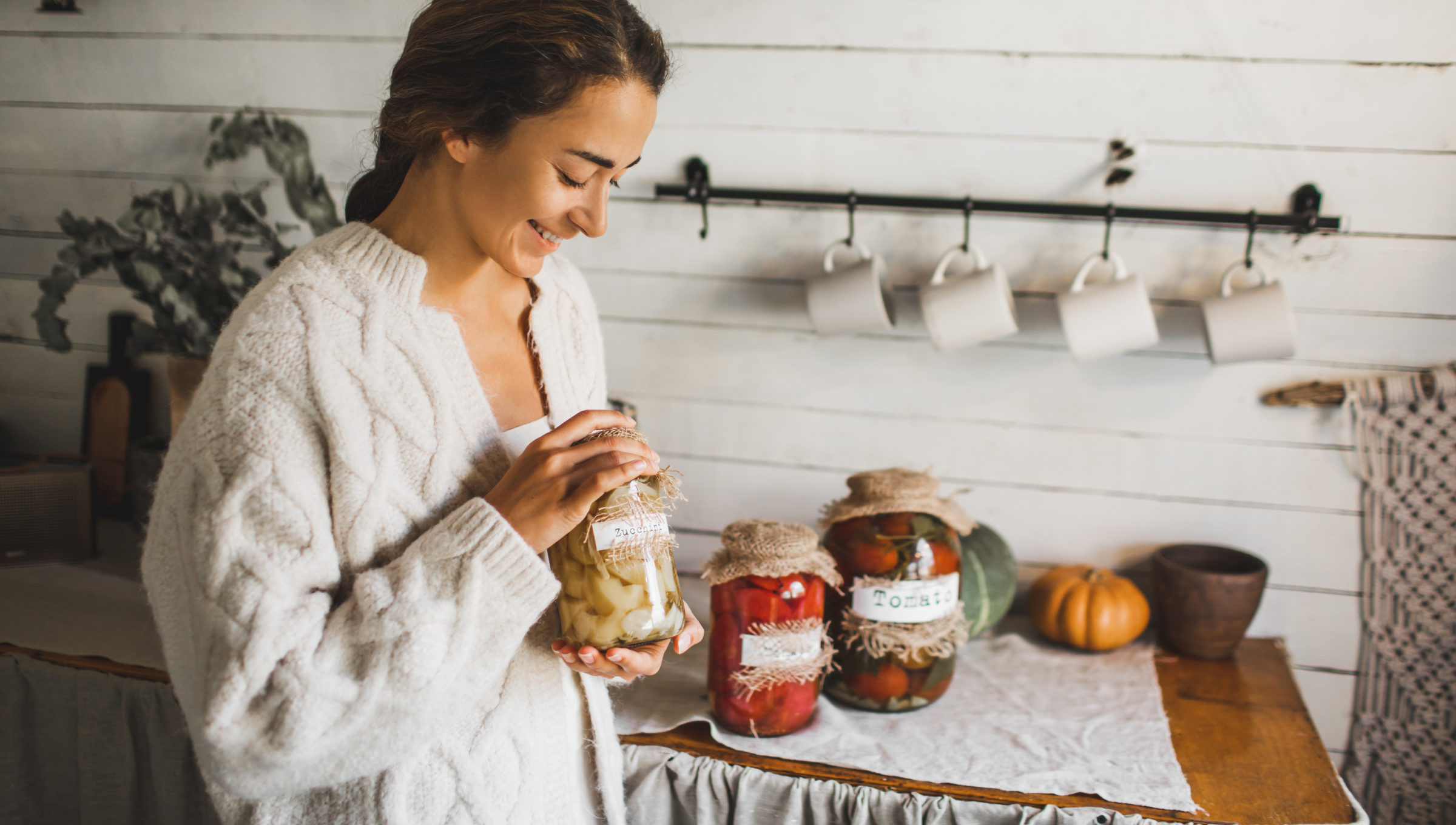 Frau mit Einmachgläsern mit fermentiertem Gemüse. 