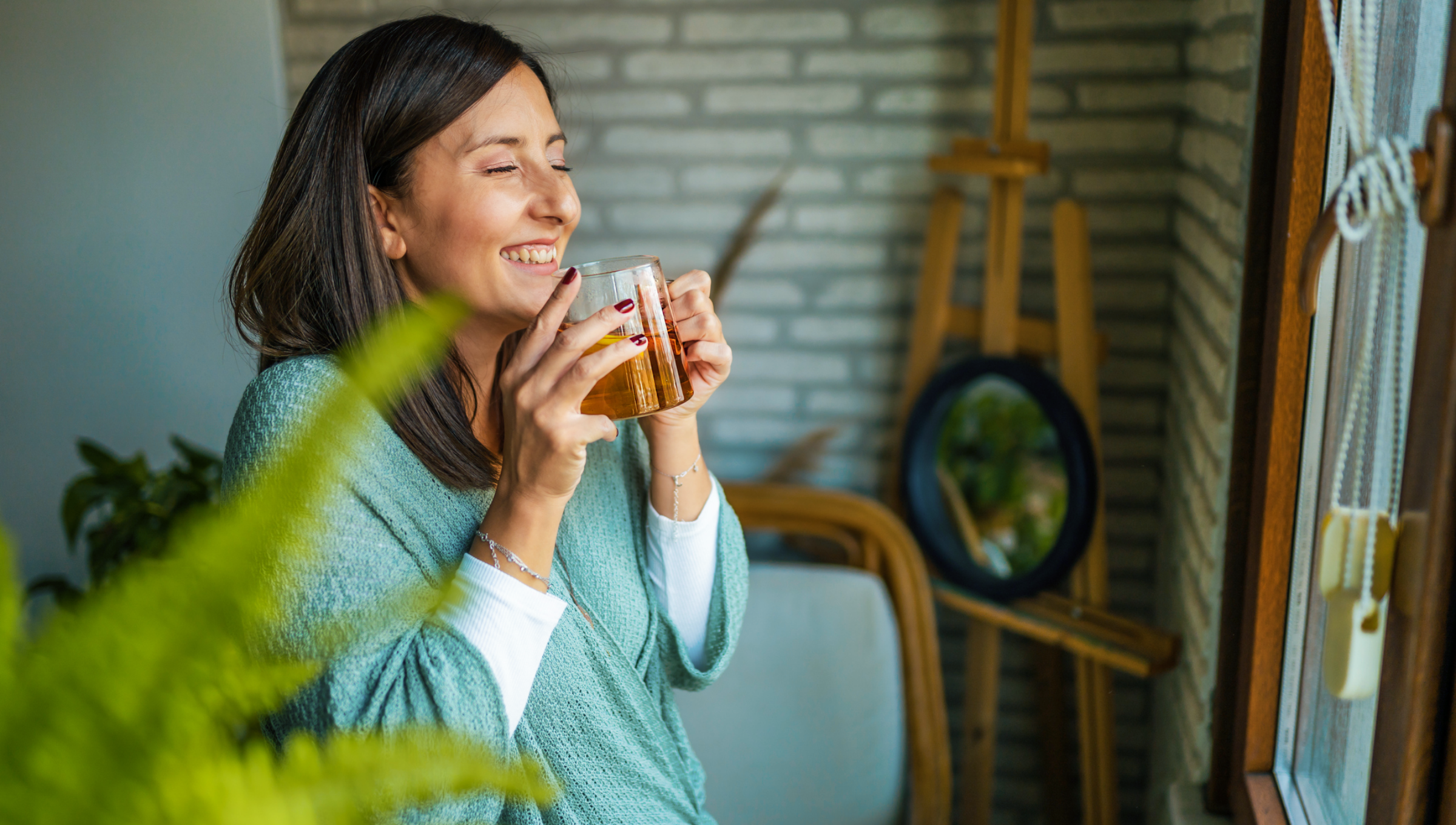 Frau genießt lächelnd eine große Tasse Tee