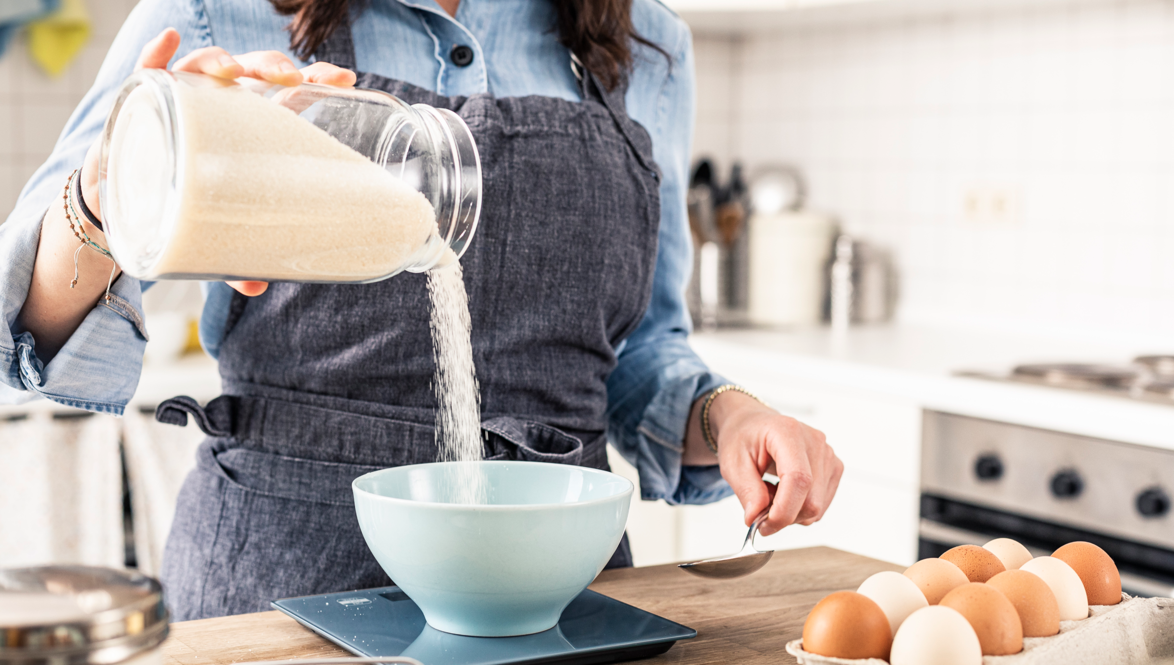 Person schält Apfel in moderner Küche, weitere Gemüsereste auf der Arbeitsplatte.