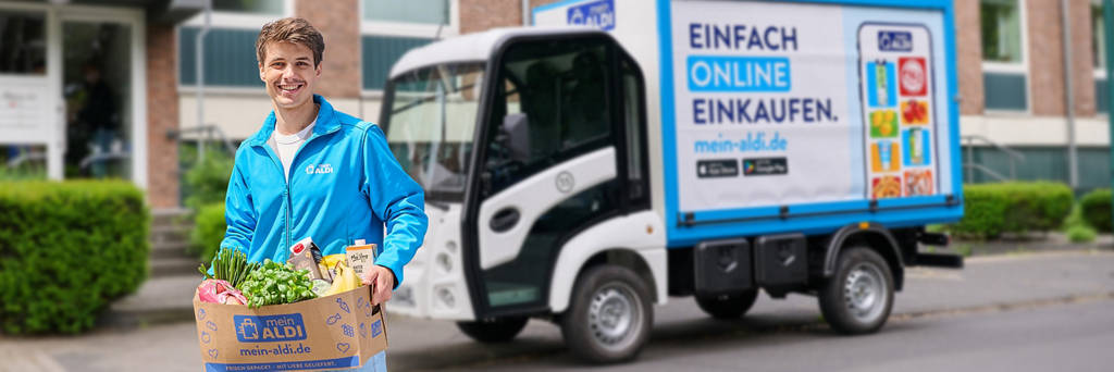 Lieferfahrer mit Einkauf kommt im E-Fahrzeug!