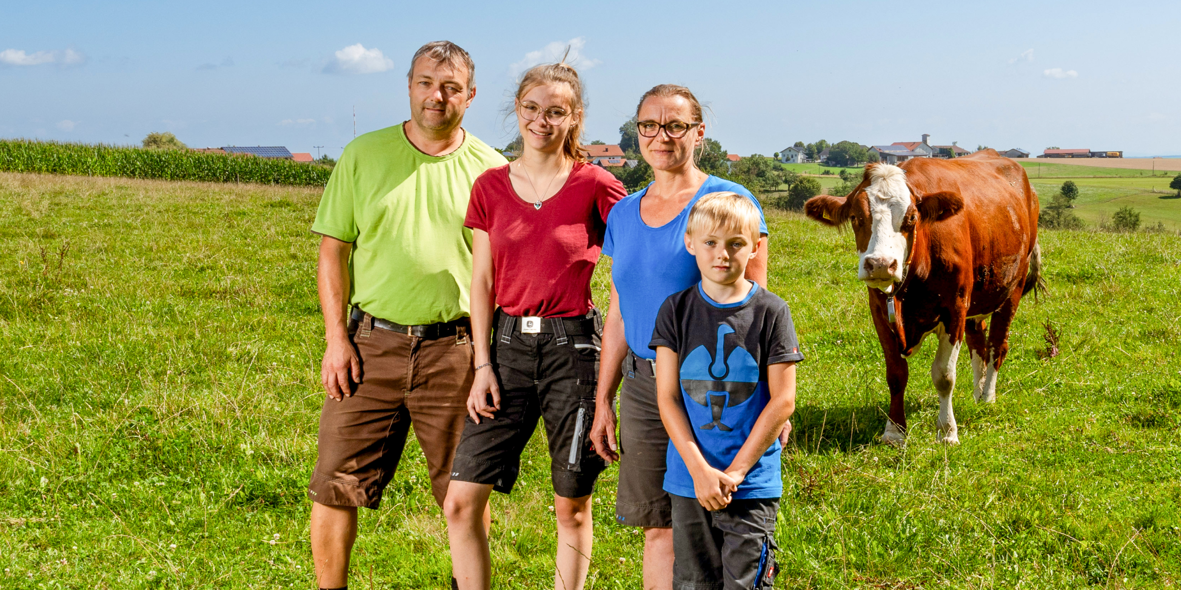 Familie Karch steht gemeinsam auf der Wiese.
